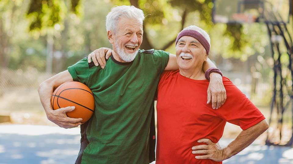 Two older men playing basketball
