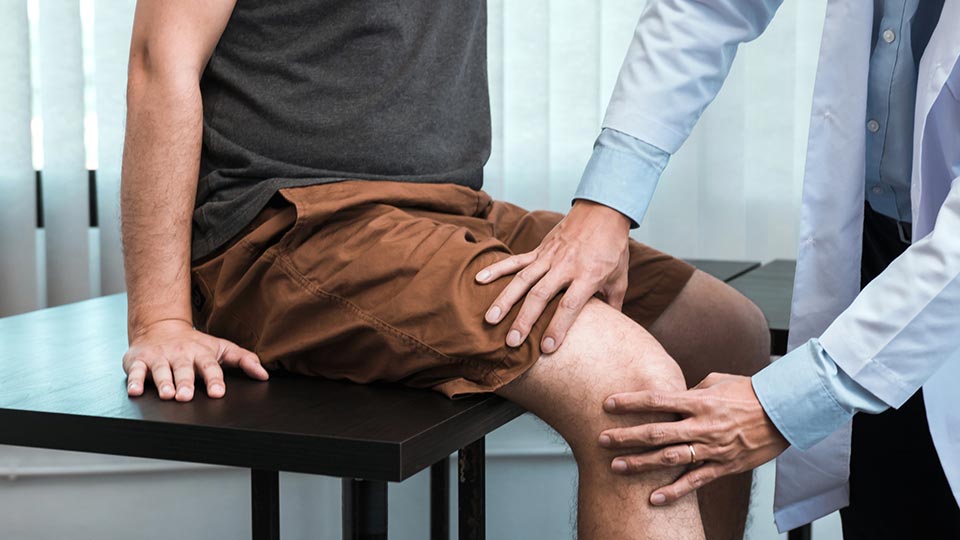 Orthopedic surgeon checking patient's knee pain