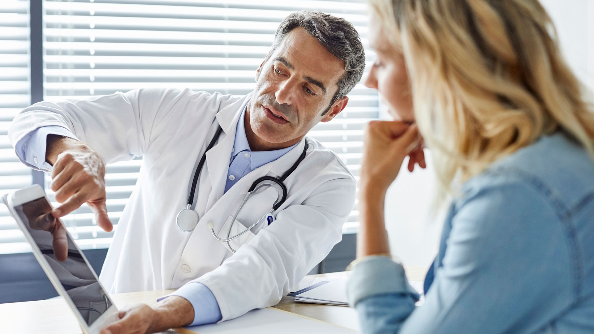 Doctor and patient looking at tablet.