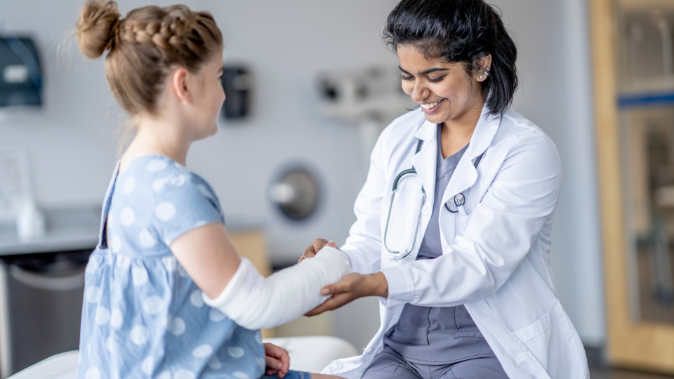 Doctor checking a child's arm cast