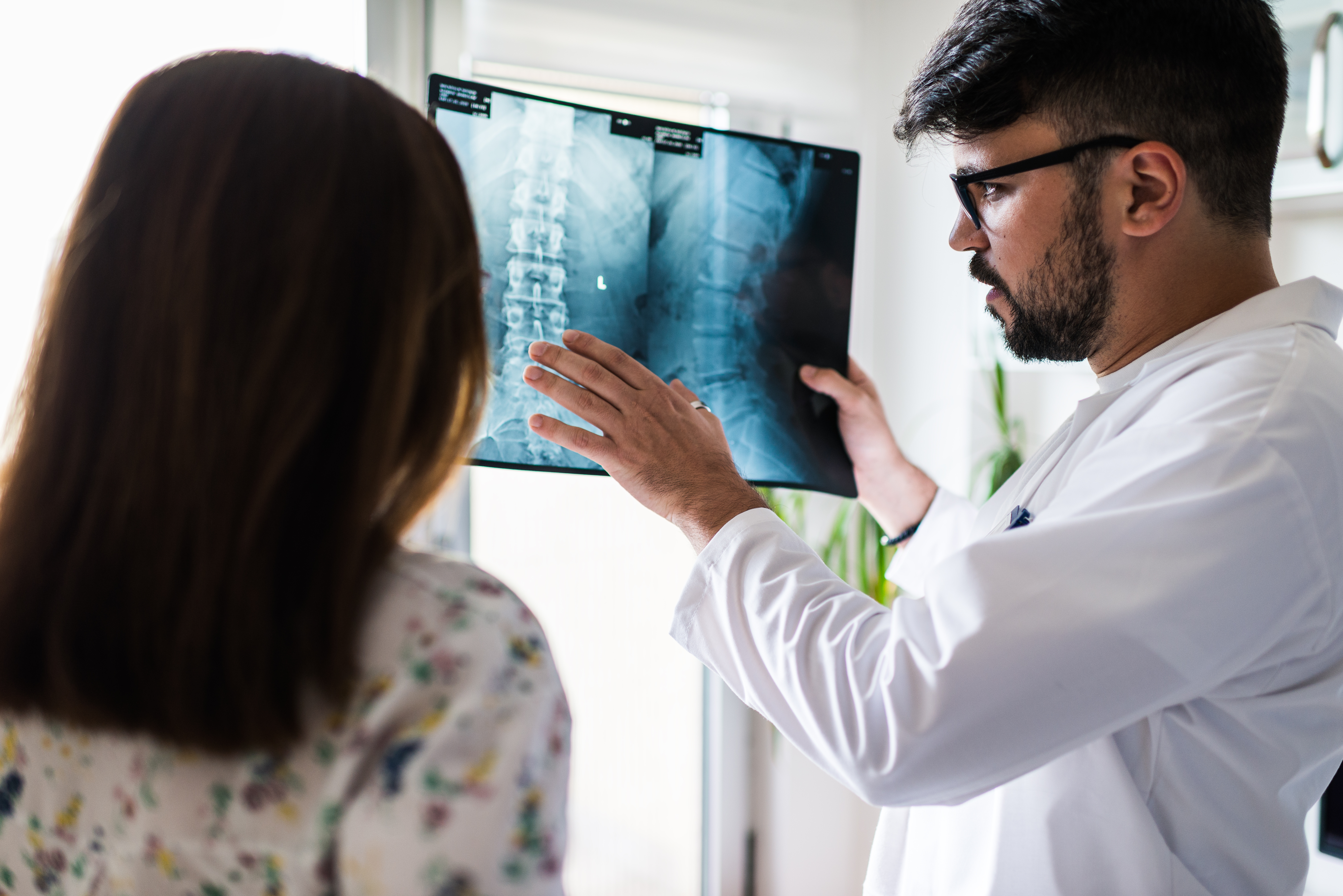 Doctor reviewing spine x-ray with patient