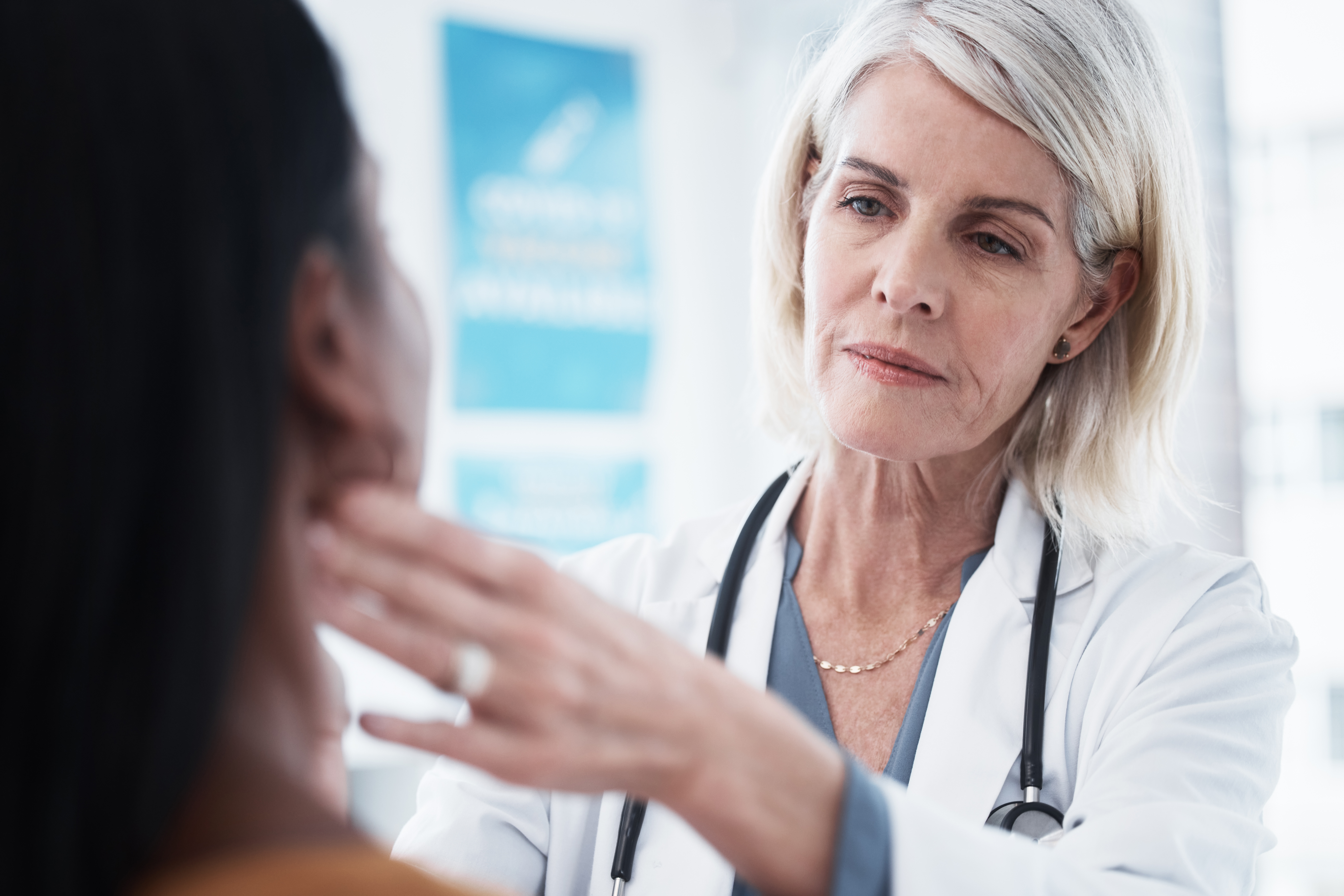 Female doctor examining a patient's lymph nodes on the throat