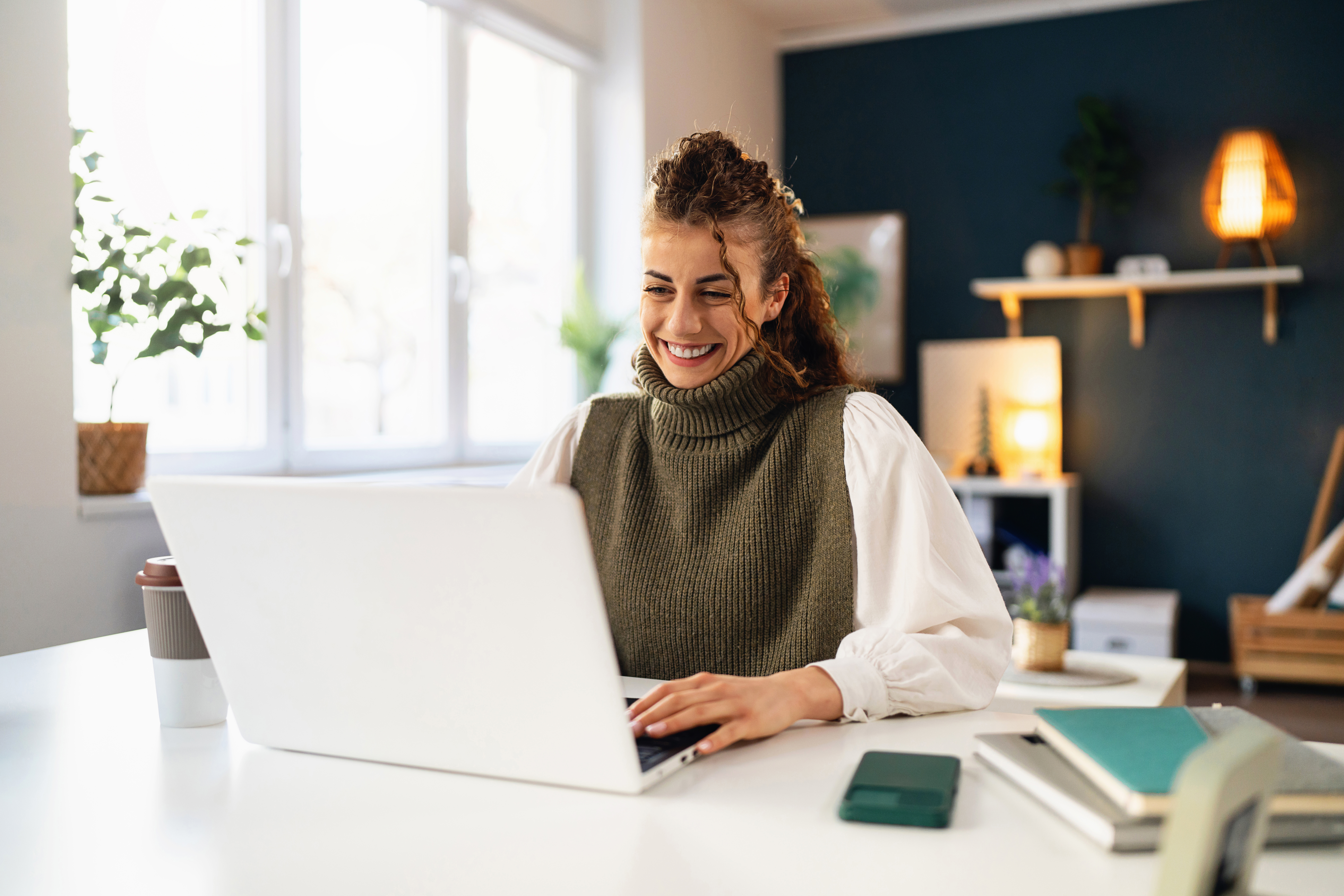 A woman looking at her computer and smiling