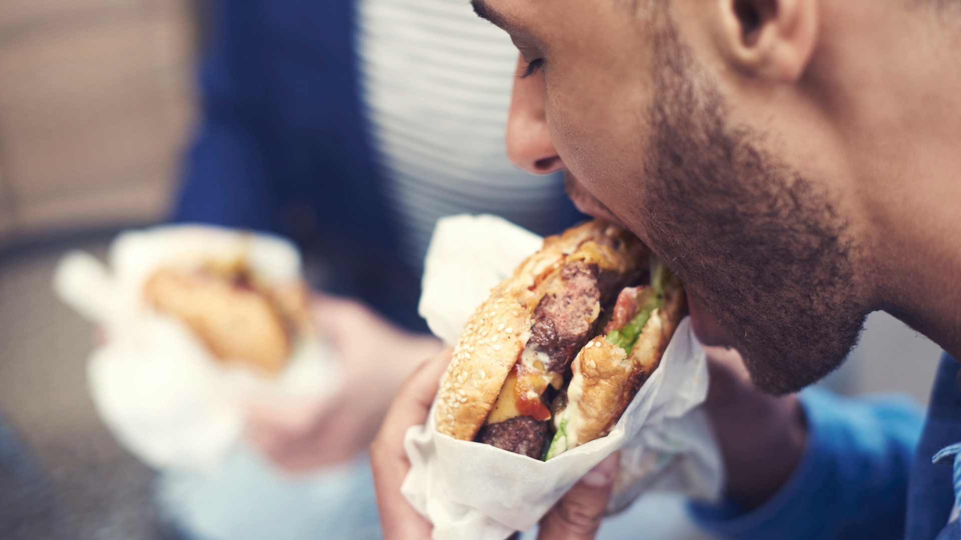 man eating a cheeseburger