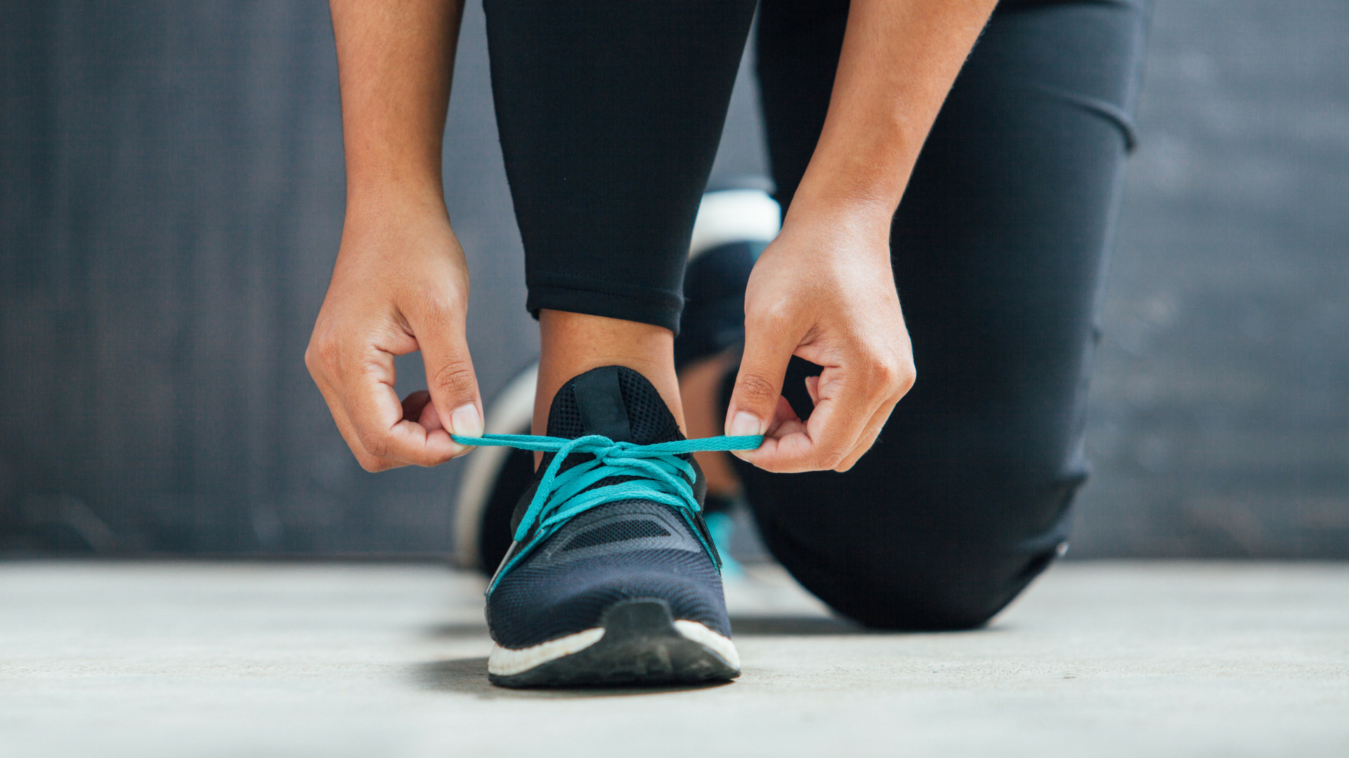 woman tying running shoe