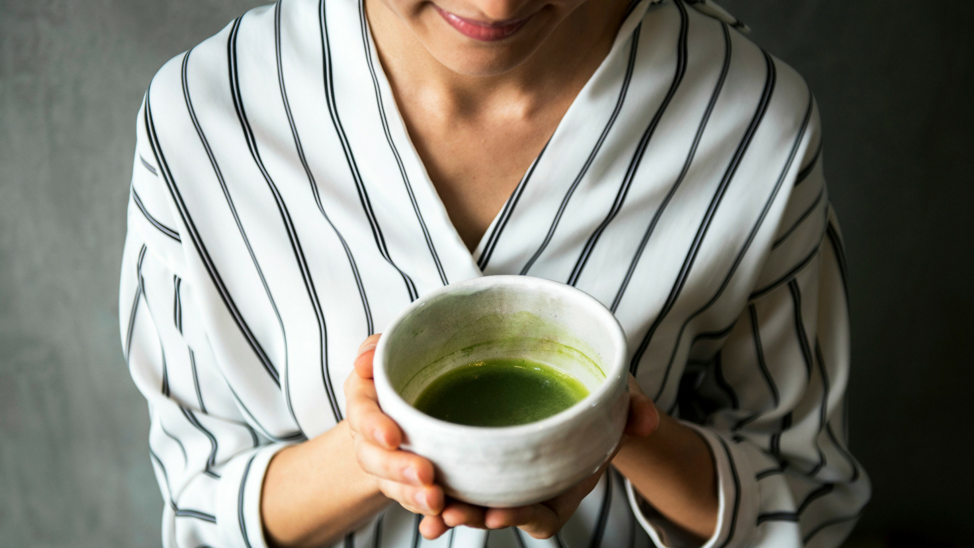 woman holding a cup of matcha