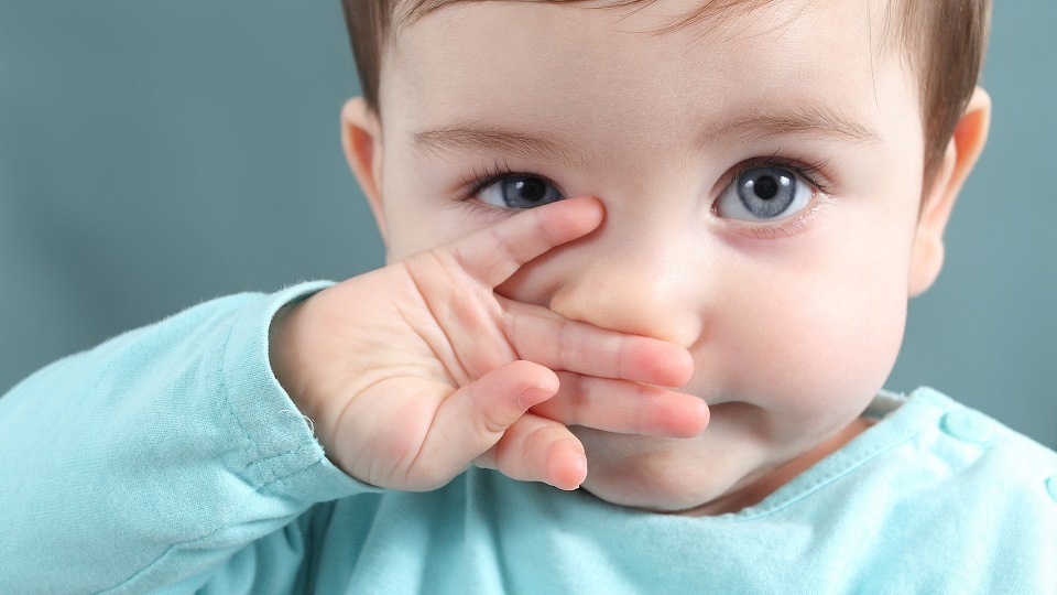 baby holding her nose