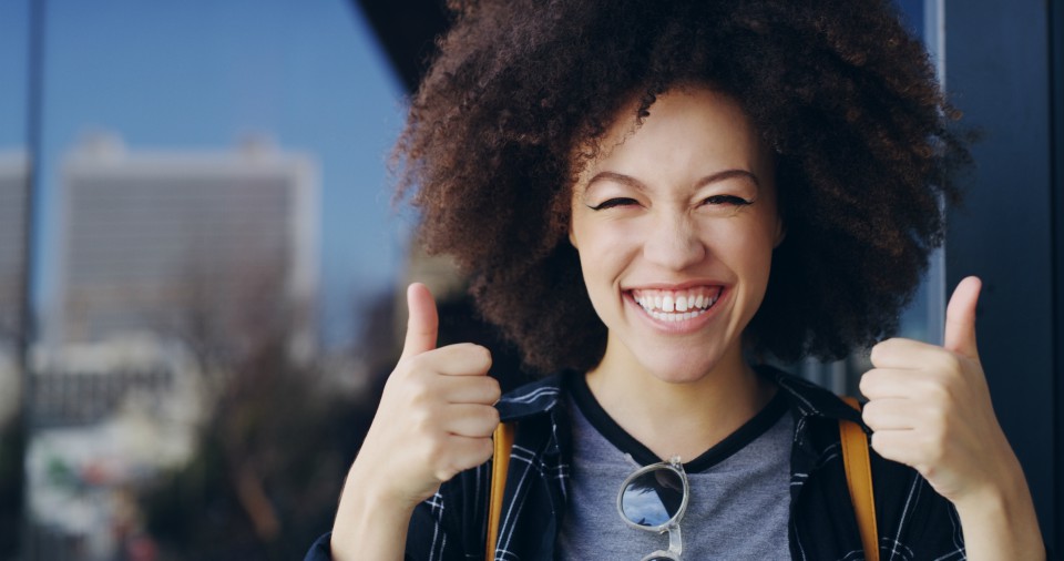 young woman giving thumbs up sign