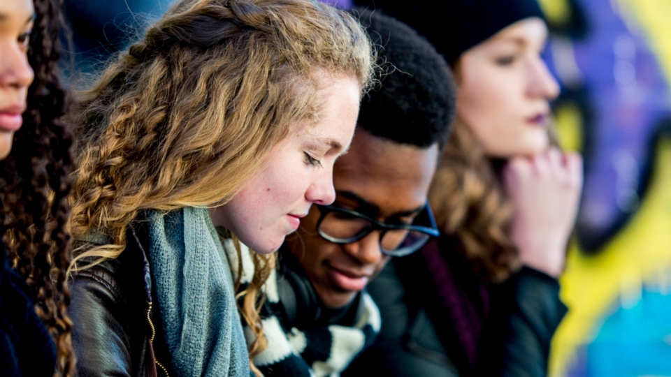 two teenagers looking at smart phone