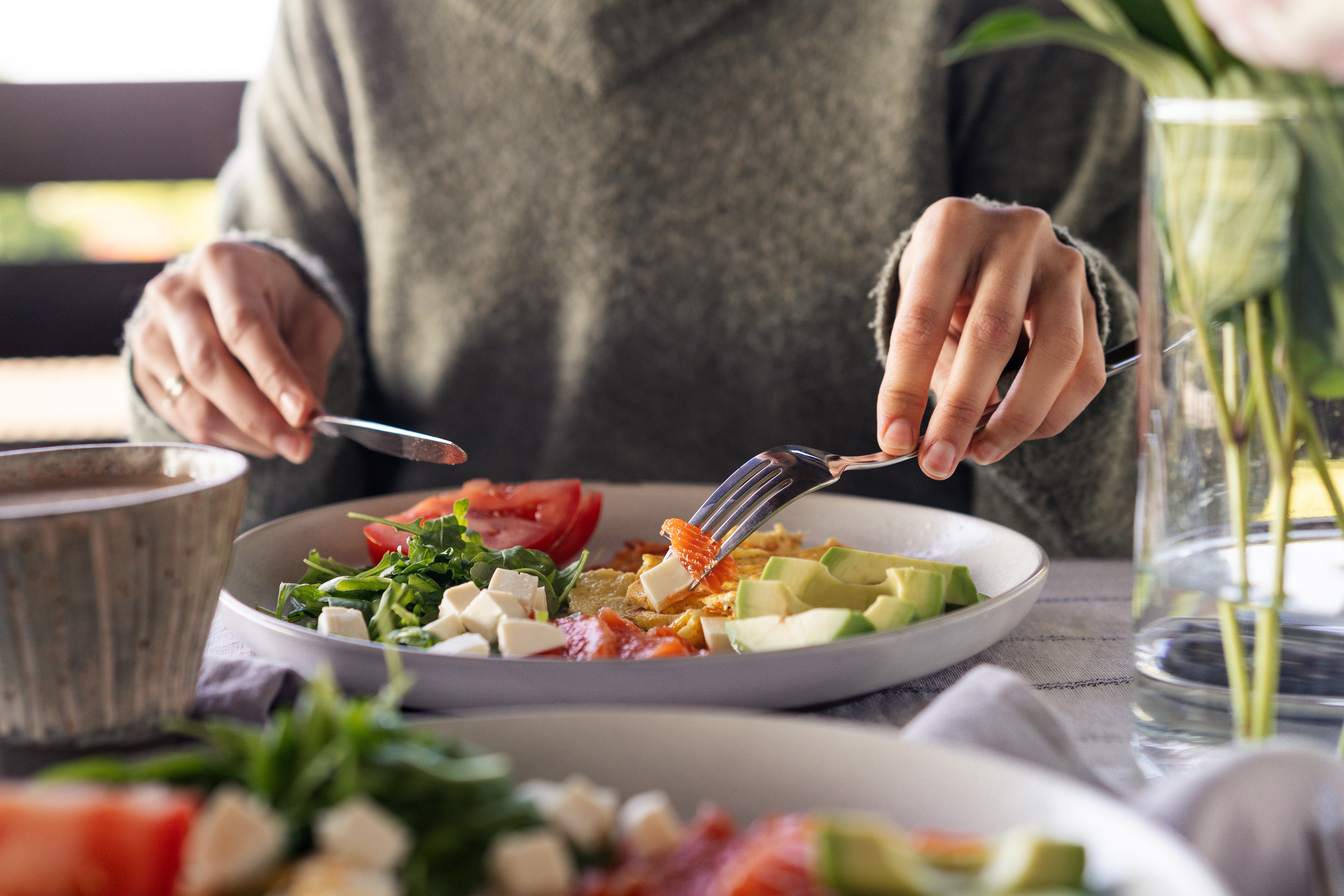 A person eating from a healthy plate of food
