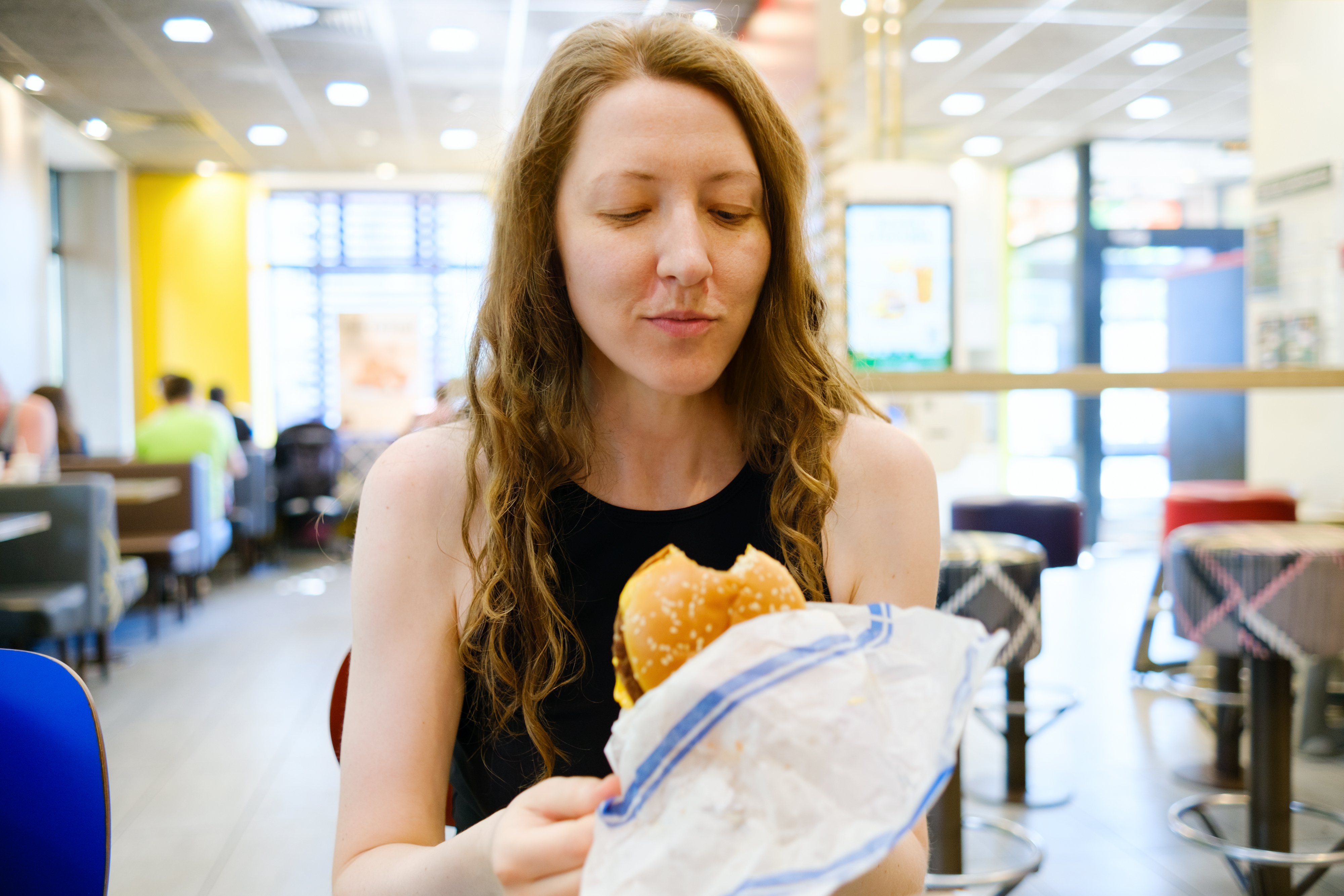 a woman eating a fast food burger 
