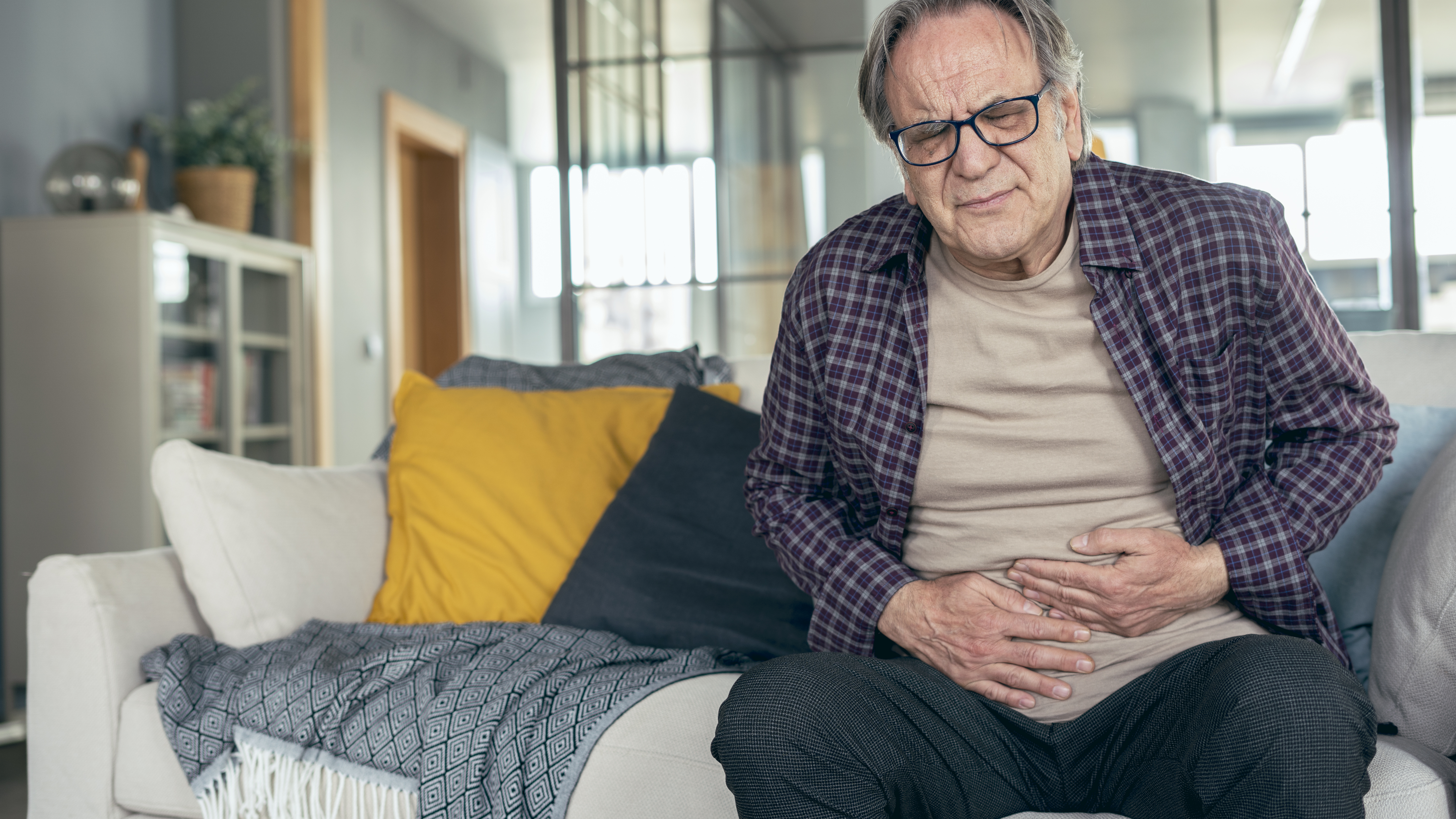 A man holds his stomach in pain