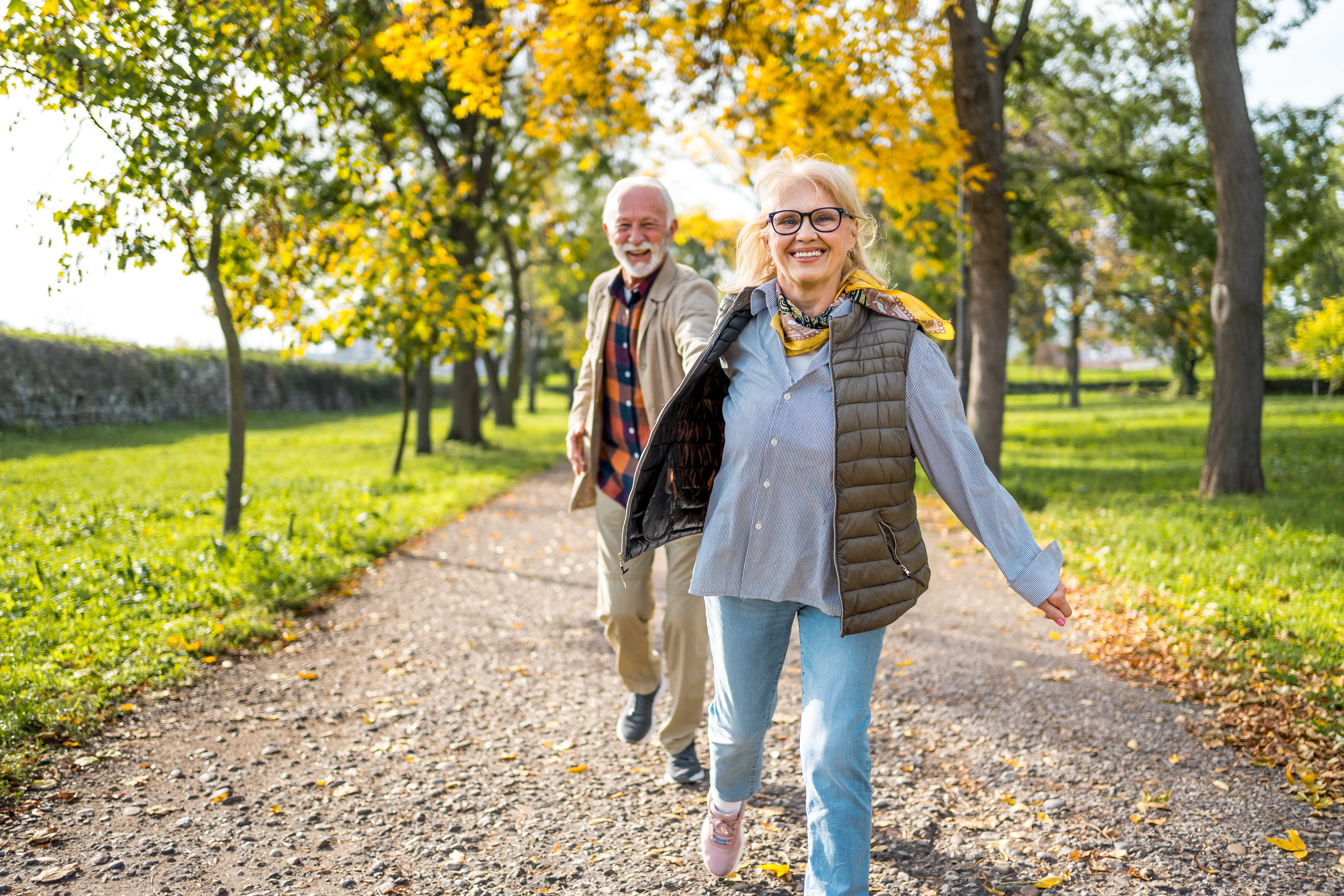 an older couple walking together along a scenic trail
