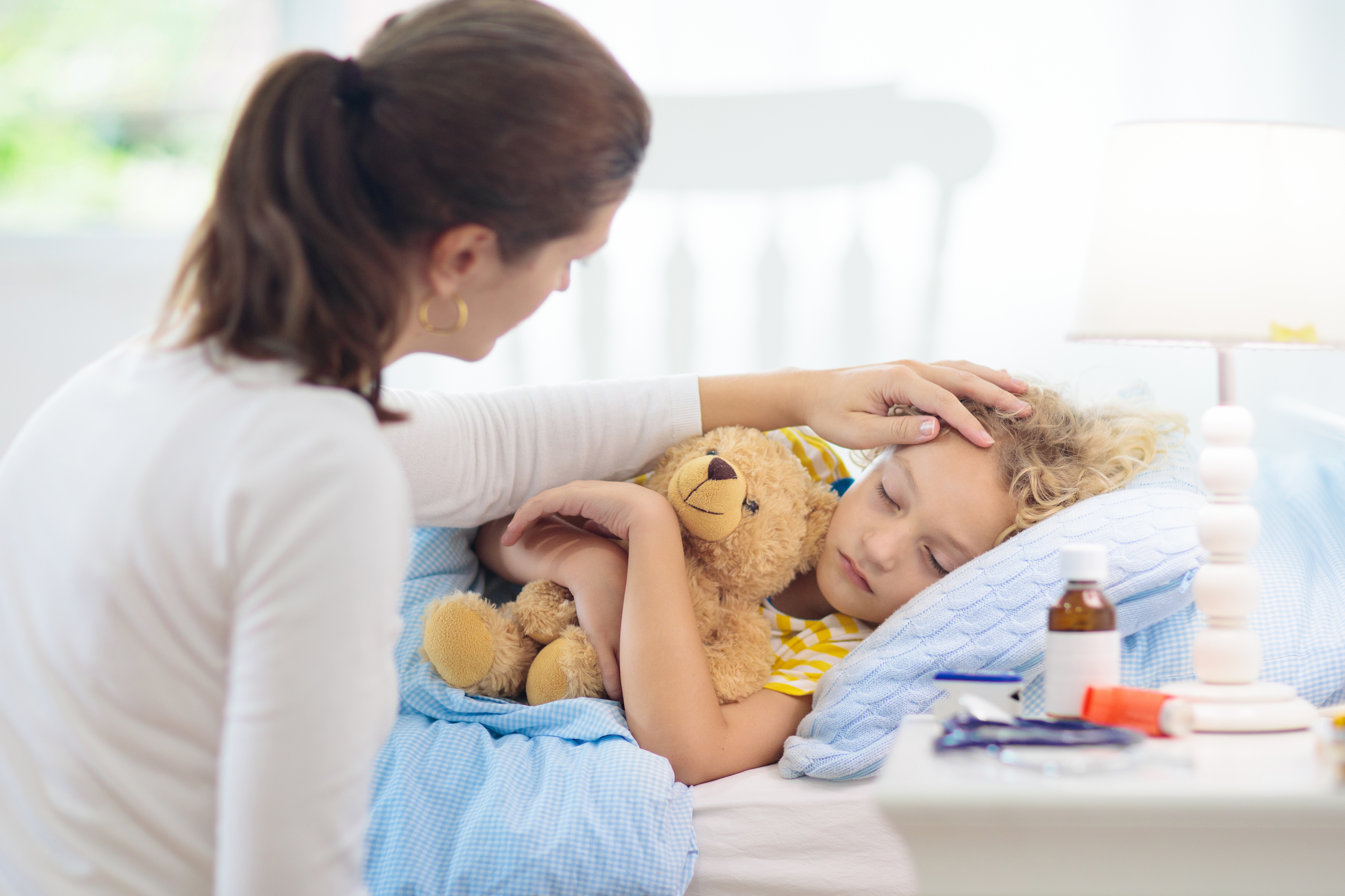 Mother with ill child lying in bed