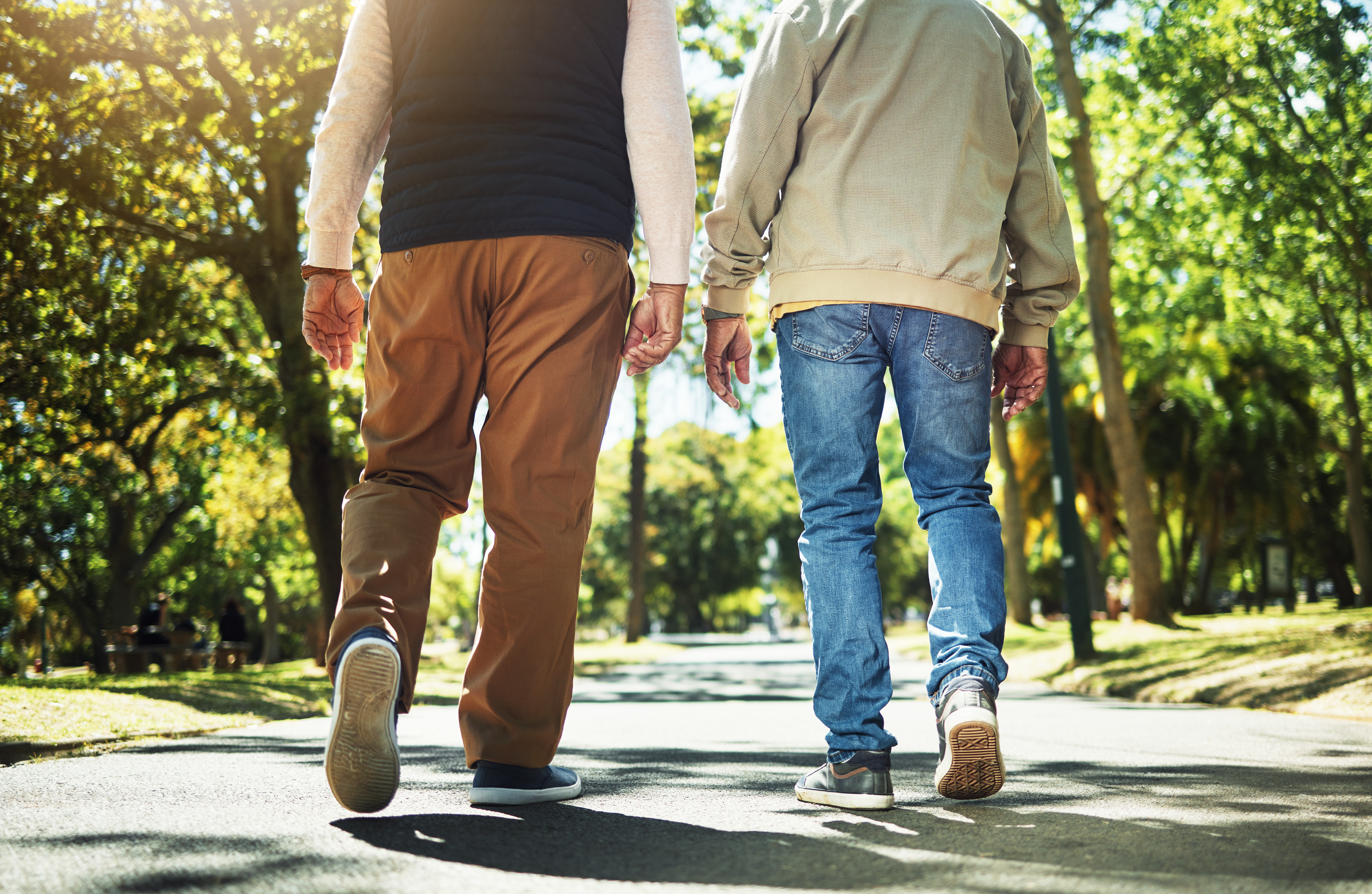 older couple shown walking down the road on a sunny day