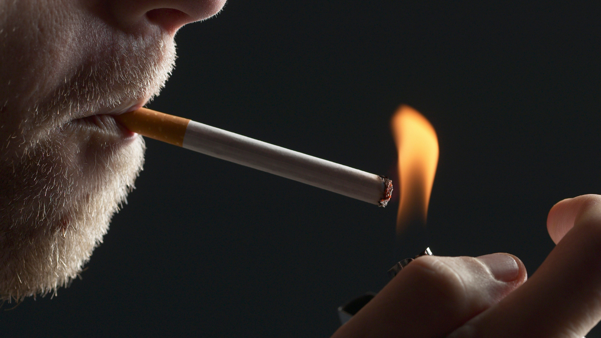 man lighting a cigarette
