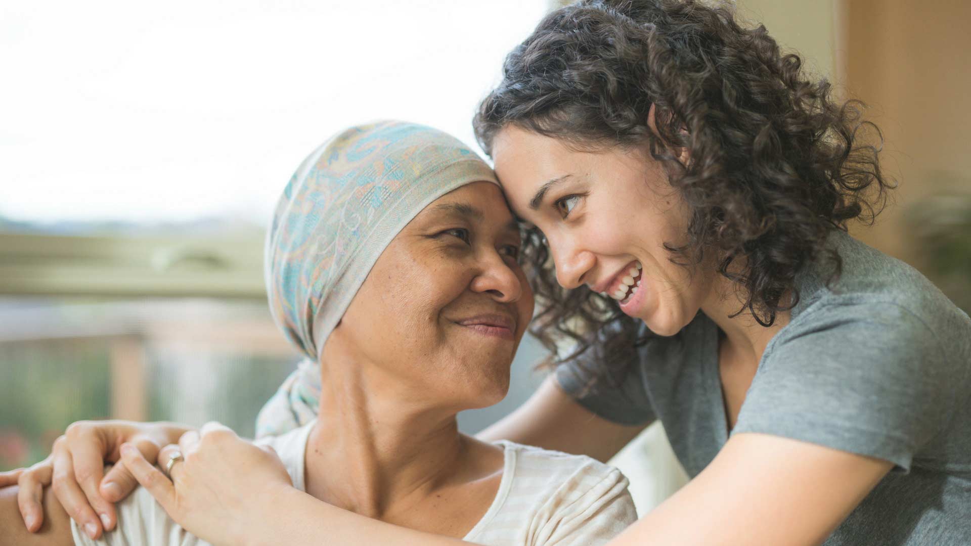 daughter hugging mother in cancer treatment
