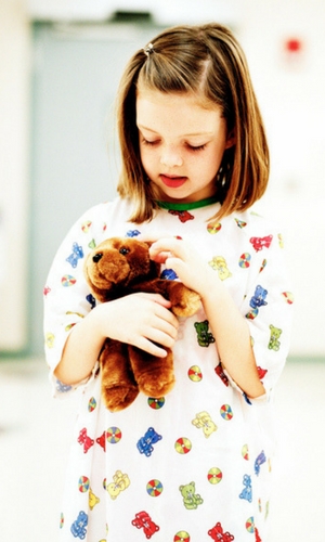 Girl in Hospital Gown Holding Teddy Bear