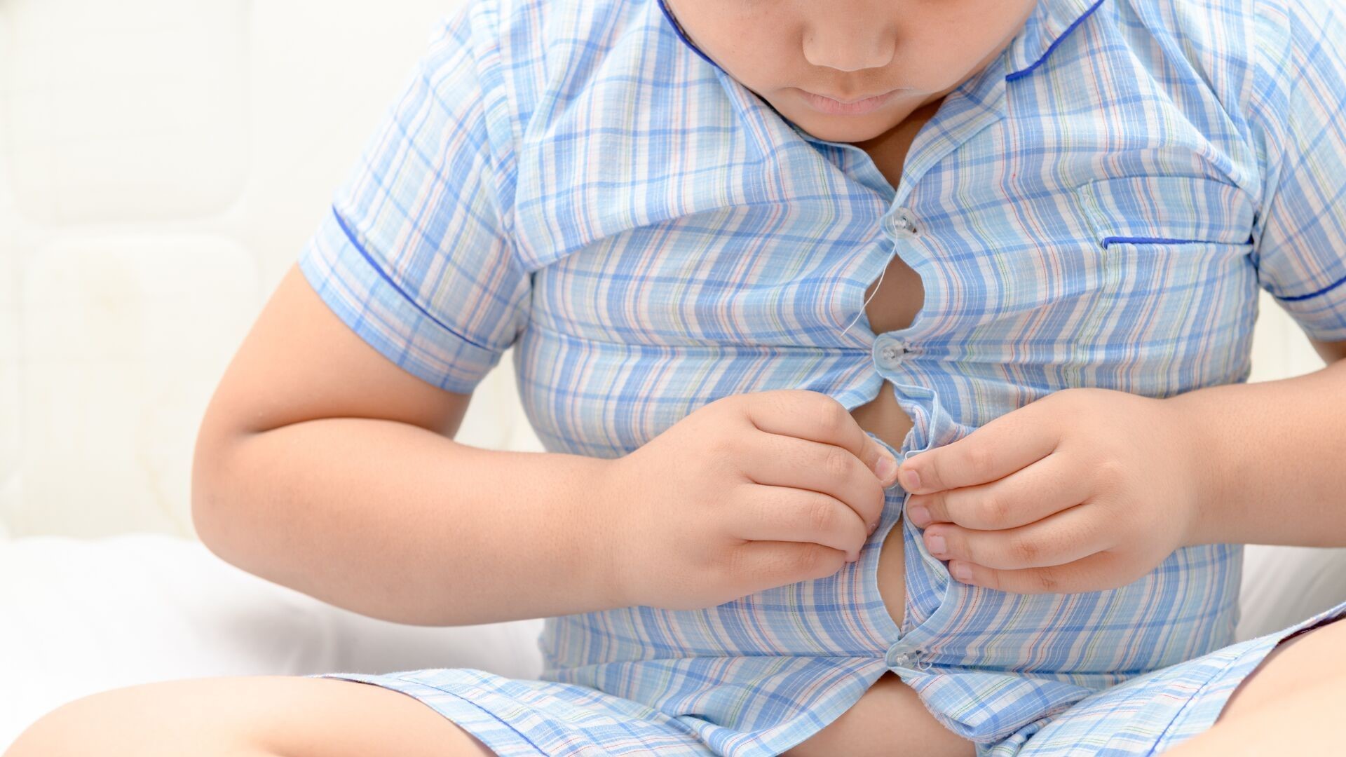 child buttoning his shirt