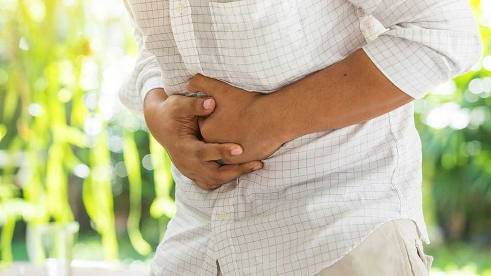 Man holding his stomach due to digestive distress