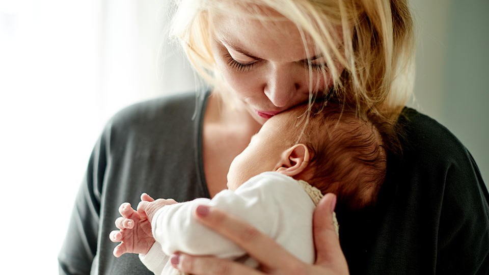 Mother kissing baby