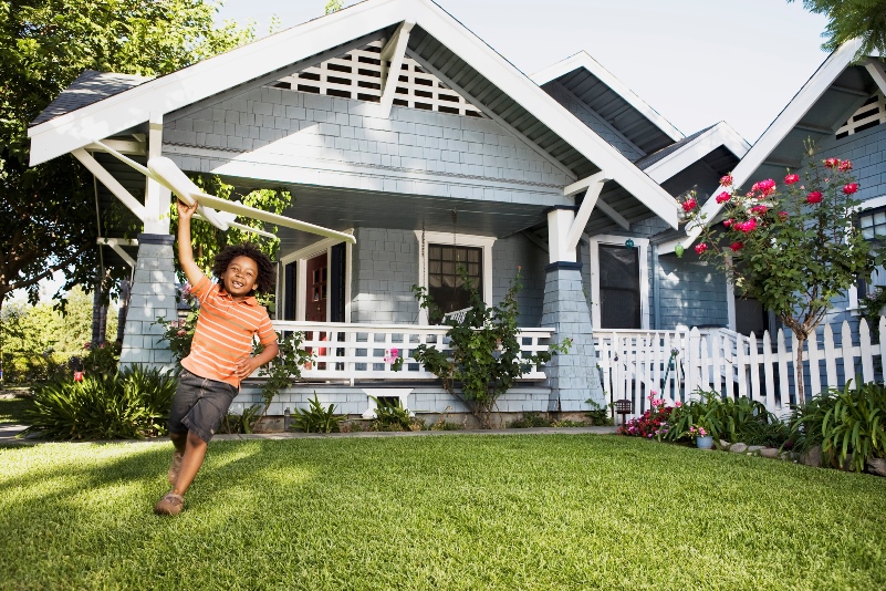 Boy playing with an airplane toy in the front yard sized