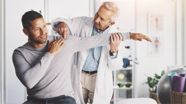 A doctor working on a patient's shoulder movement